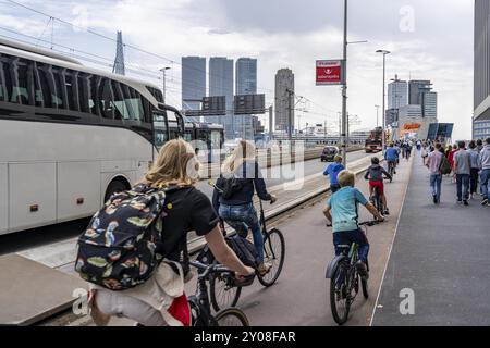 Radfahrer auf dem Radweg der Erasmus-Brücke über die Nieuwe Maas, Skyline der Wolkenkratzer auf dem Kop van Zuid, Rotterdam, Niederlande Stockfoto