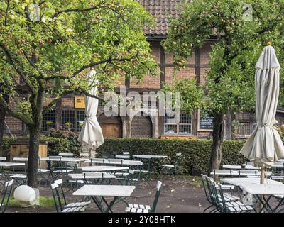 Gemütliches Freiluft-Café mit Tischen und Stühlen unter Bäumen in herbstlichem Ambiente, Bad Zwischenahn, ammerland, deutschland Stockfoto