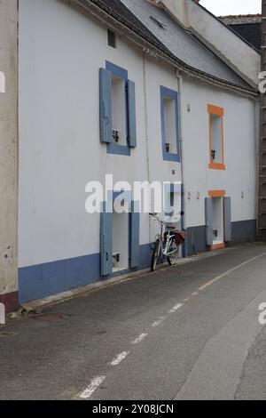 Das Fahrrad parkte vor dem weiß lackierten Haus in der Rue Saint Nicolas, Sauzon, Belle Ile en Mer, Bretagne, Frankreich Stockfoto
