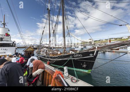 HUSAVIK, ISLAND, 29. JUNI: Klassischer alter Schoner im Hafen von Husavik mit verankerten Segelbooten und Bergen im Hintergrund am 29. Juni 2013 in Husa Stockfoto