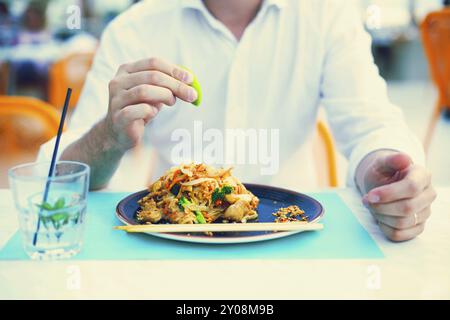 Mann im Thai Restaurant essen Pad Thai. Nahaufnahme Stockfoto