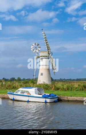 Thurne Drainage Mill im Norfolk Broads National Park in Großbritannien mit einem Boot im Vordergrund an einem Sommertag in Portraitorientierung Stockfoto