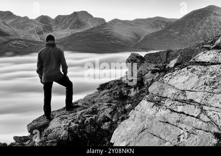 Wanderer mit Blick über das nebelbedeckte Atndalen-Tal zum Gipfel des Rondslottet im Rondane-Nationalpark, Hedmark Fylke, Norwegen, Oktober 2011, Euro Stockfoto