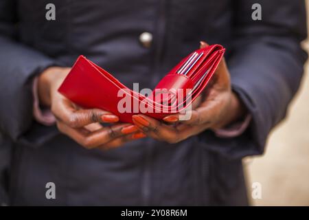 Die Frau hält die rote Brieftasche in der Hand Stockfoto