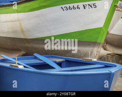 Nahaufnahme eines blauen Bootes vor einem größeren weiß-grünen Boot im Hafen Funchal, madeira, portugal Stockfoto