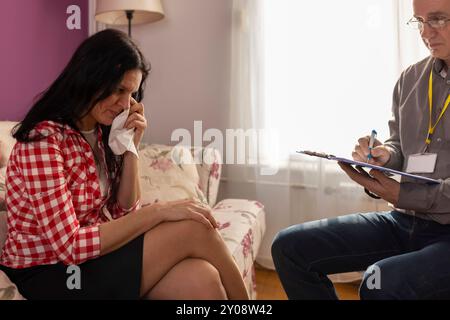 Ein Psychologe untersucht und hört zu, wie die Patientin zu Hause ist. Reifer männlicher Arzt gibt Rat und Beratung, um jungen Frauen bei der Lösung des Problems zu helfen. Psyc Stockfoto