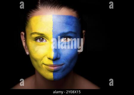 Porträt einer Frau mit der Flagge der Ukraine im Gesicht Stockfoto