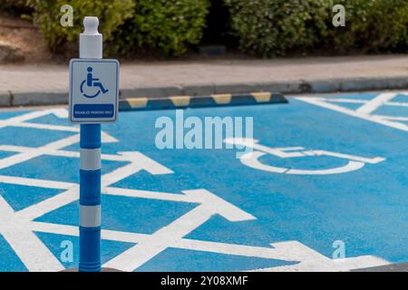 Blau lackierter Rollstuhlparkplatz auf einem Parkplatz. Stockfoto