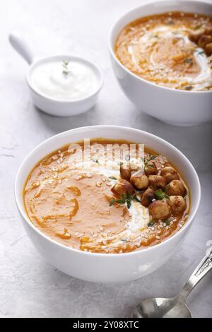 Karotte Kürbissuppe mit würzige Kichererbsen und Sesam auf grauem Stein Background Copy space Stockfoto