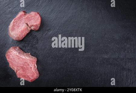 Stück rohes Rinderfilet auf einer Schieferplatte (selektiver Fokus, Nahaufnahme) Stockfoto