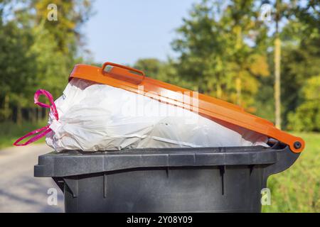 Papierkorb mit Müll auf der Straße in der Natur gefüllt Stockfoto