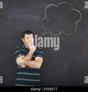 Junger Mann denkt. Kreidezeichnung auf dunklem Hintergrund Stockfoto