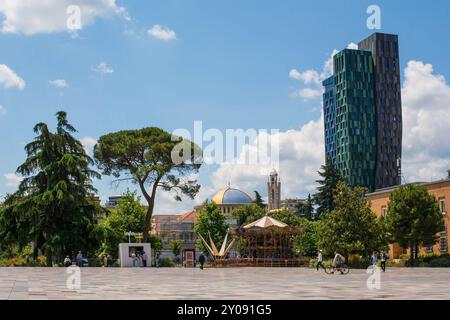 Tirana, Albanien - Mai 30 2024. Skanderbeg Square. Rechts - 4Evergreen Tower. Zentrum - Neue Kathedrale Der Wiederbelebung. Links – Tirana Eye Riesenrad Stockfoto