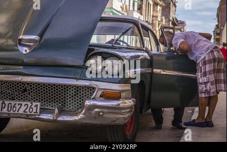 Havanna, Kuba am 23. Dezember 2015: Kubanischer Mechaniker versucht, einen amerikanischen Oldtimer aus den 1950er Jahren zu reparieren, der einen Ausfall hat. Die meisten Autos in Kuba sind Oldtim Stockfoto