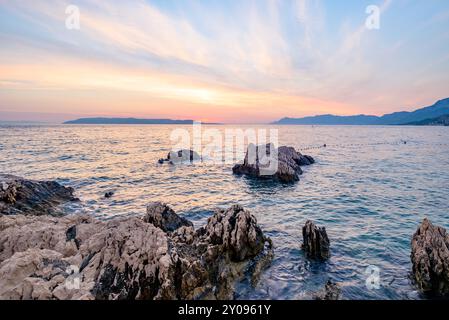 Farbenfroher Sonnenuntergang an der Makarska Riviera, beliebte touristische Küste der Adria im Kreis Split-Dalmatien der Republik Kroatien Stockfoto