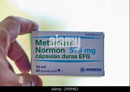 Viladecans, Barcelona-01.September 2024: Hand hält eine Schachtel Metamizol Normon 575 mg zur Schmerzbehandlung mit Schwerpunkt auf Dosierung und oralem Weg. Ideal für Stockfoto