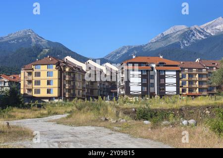 Hölzerne Chalet-Hotelhäuser und im Sommer Berggipfel der Pirin im bulgarischen Ganzjahresresort Bansko, Bulgarien, Europa Stockfoto