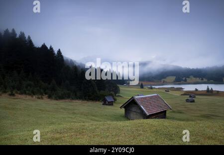 Holzhütten und Nebel über dem Geroldsee in der Abenddämmerung, Bayerische Alpen Stockfoto