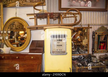 Paris, Frankreich. August 2022. Ein Schlitten und eine alte Benzinpumpe auf dem Flohmarkt in Paris Stockfoto