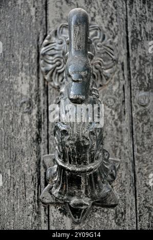 Ein sehr alter, modischer Türklopfer in einer Holztür Stockfoto