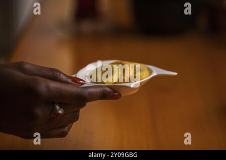 Die Hand hält die weiße Schüssel mit Zitronenscheiben Stockfoto
