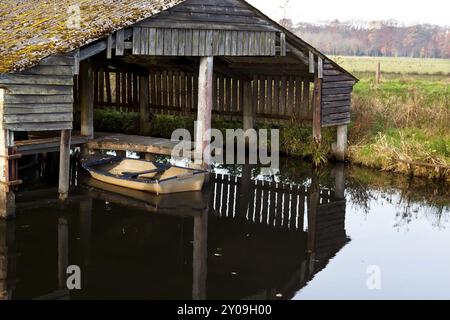 Altes Boot in hölzerner Fischerhütte auf dem Wasser Stockfoto