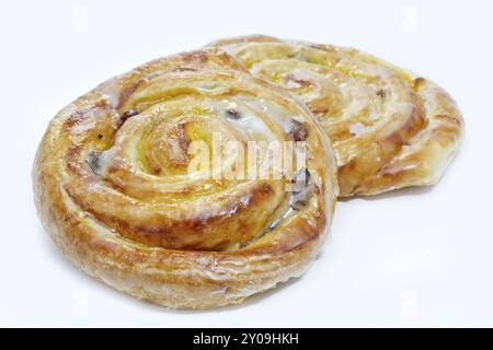 Zwei Puddingbrötchen mit Sultaninen auf weißem Hintergrund Stockfoto