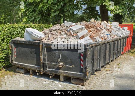 Großes Metall Abfallbehälter mit Steinen, Wc und anderen Schutt aufgefüllt Stockfoto