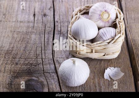 Chinesische solo Knoblauch in einem kleinen Weidenkorb auf hölzernen Hintergrund. Selektiven Fokus Stockfoto