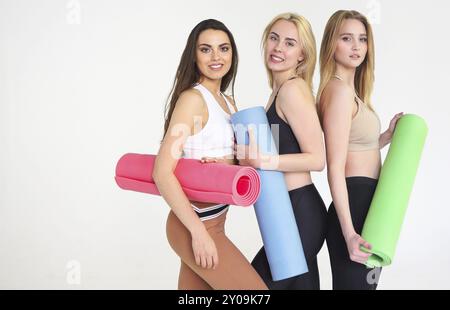 Gruppe der tausendjährigen gerne attraktive schlanke Frauen in einer Zeile, Yoga Matte stehend Ruhen fühlt sich gut und gesund nach dem Training. Professionelle Mitarbeiter Stockfoto