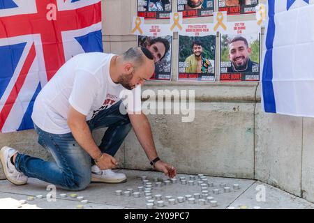 The Strand, London, Großbritannien. September 2024. Jonny Daniels, ein bekannter Social-Media-Aktivist und Verfechter jüdischer Rechte, zündet bei einer Mahnwache eine Kerze an, die in Erinnerung an sechs Geiseln gehalten wird, die von der Hamas in Gefangenschaft brutal ermordet wurden. Quelle: Amanda Rose/Alamy Live News Stockfoto