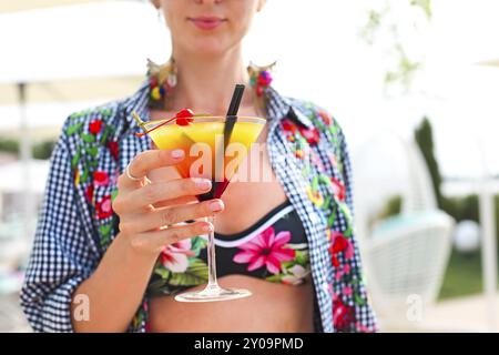 Exotischen cocktail Glas in womans Hand am Pool Stockfoto