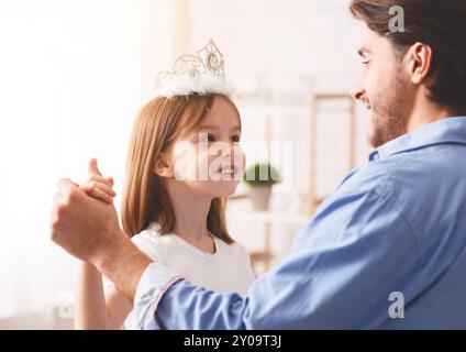 Kleine Prinzen tanzen mit ihrem Vater zu Hause Stockfoto