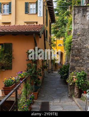 Varenna, Italien, 26. April 2024. Enge kopfsteingepflasterte Gasse in der malerischen Stadt Varenna am Comer See Stockfoto