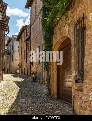 Typische Kopfsteinpflasterstraße in Castell'Arquato an einem sonnigen Tag, Emilia-Romagna, Italien Stockfoto