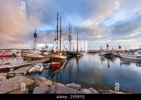 HUSAVIK, ISLAND, 29. JUNI: Am 29. Juni 2013 in Husavik verankerte Walbeobachtungsschoner bei Sonnenaufgang im Hafen von Husavik und in den Bergen im Hintergrund, Stockfoto