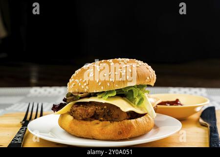 Hausgemachte Chicken Burger mit Käse und Gemüse in weiße Platte auf einem Holzbrett Stockfoto