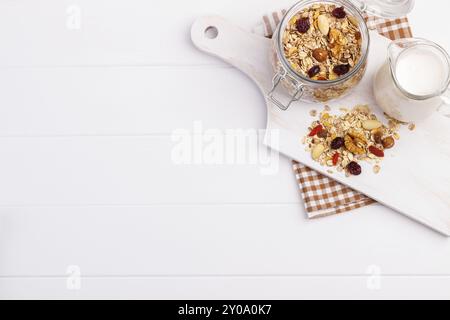 Schüssel hausgemachtes Müsli mit Nüssen, Beeren, getrockneten Früchten, Glas Milch und Honig. Gesundes Frühstück. Draufsicht Stockfoto