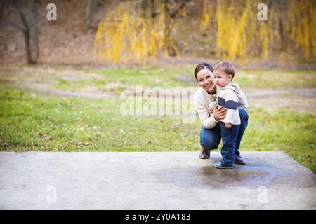 Junge Mutter mit Sohn im Herbst Park. Glückliche Familien-Konzept Stockfoto