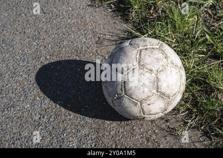 Gealterte weiße Fußball auf Asphalt Stockfoto