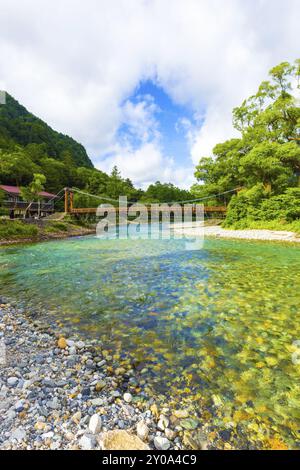 Blauer Himmel bricht an einem frühen Morgen in den nördlichen Japanischen Alpen durch Wolken über der Kappa-Brücke über das klare Alpenwasser des Azusa-Flusses Stockfoto