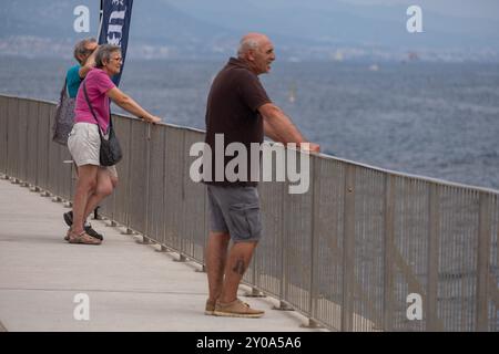 Barcelona, Spanien. September 2024. Die Zuschauer sehen die America's Cup-Regatta am Wellenbrecher von Port Olimpic. Zahlreiche Zuschauer, Einwohner, Touristen und Profis sind an der Mole des olympischen Hafens von Barcelona gekommen, um den dritten Regattentag mit dem Round Robin America's Cup Louis Vuitton live zu beobachten. Quelle: SOPA Images Limited/Alamy Live News Stockfoto