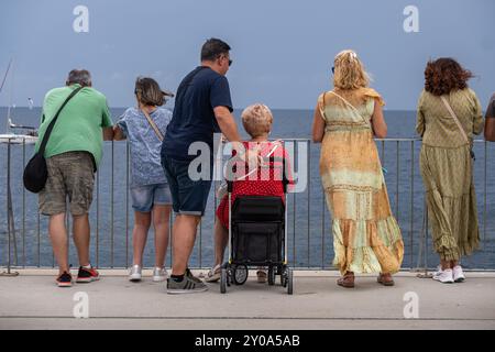 Barcelona, Spanien. September 2024. Die Familie sieht die America's Cup Regatta vom Wellenbrecher von Port Olimpic aus. Zahlreiche Zuschauer, Einwohner, Touristen und Profis sind an der Mole des olympischen Hafens von Barcelona gekommen, um den dritten Regattentag mit dem Round Robin America's Cup Louis Vuitton live zu beobachten. Quelle: SOPA Images Limited/Alamy Live News Stockfoto