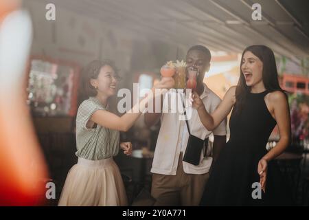 Multikulturelle Geschäftsleute genießen Drinks und jubeln den Erfolg in einer feierlichen Umgebung an Stockfoto