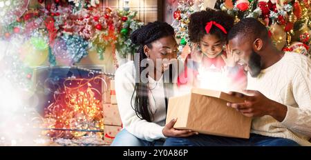 Aufgeregt schwarze Familie von drei Eröffnung scheint Weihnachten Geschenkverpackung Stockfoto