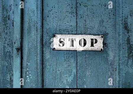 Nahaufnahme eines Schilds mit der Aufschrift Stop auf dem hölzernen Hintergrund Stockfoto