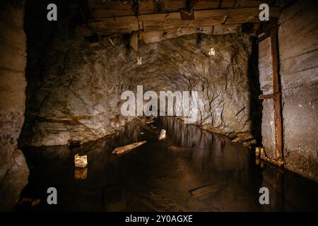 Dunkel überfluteter Beton-gewölbter Minentunnel. Stockfoto