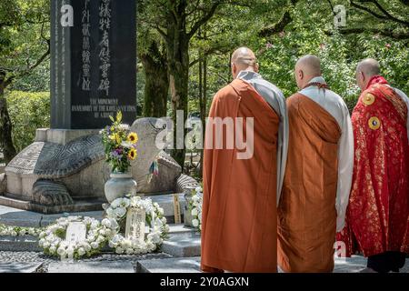 Mönche beten vor dem Cenotaph für koreanische Opfer im Hiroshima Peace Memorial Park in Hiroshima, Japan Stockfoto