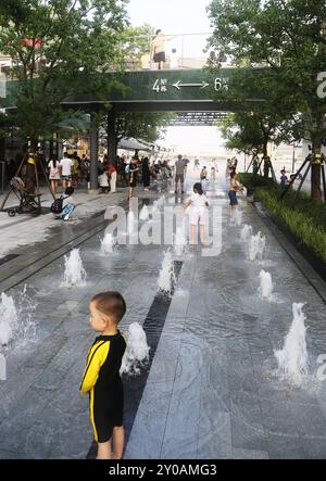 SHANGHAI, CHINA - 1. SEPTEMBER 2024 - Kinder spielen mit Wasser in einem Brunnen, um sich abzukühlen in Shanghai, China, 1. September 2024. Stockfoto