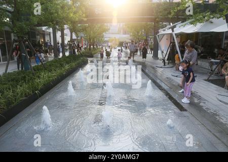 SHANGHAI, CHINA - 1. SEPTEMBER 2024 - Kinder spielen mit Wasser in einem Brunnen, um sich abzukühlen in Shanghai, China, 1. September 2024. Stockfoto